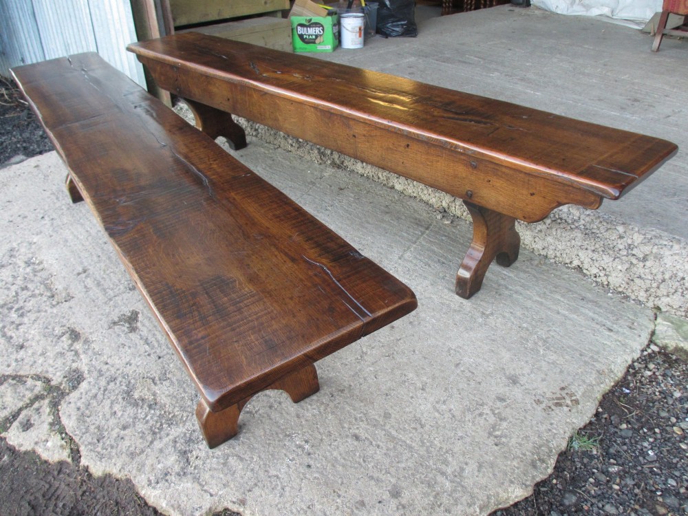 A long Edwardian solid oak bench featuring a rectangular seat and shaped trestle end supports. View III