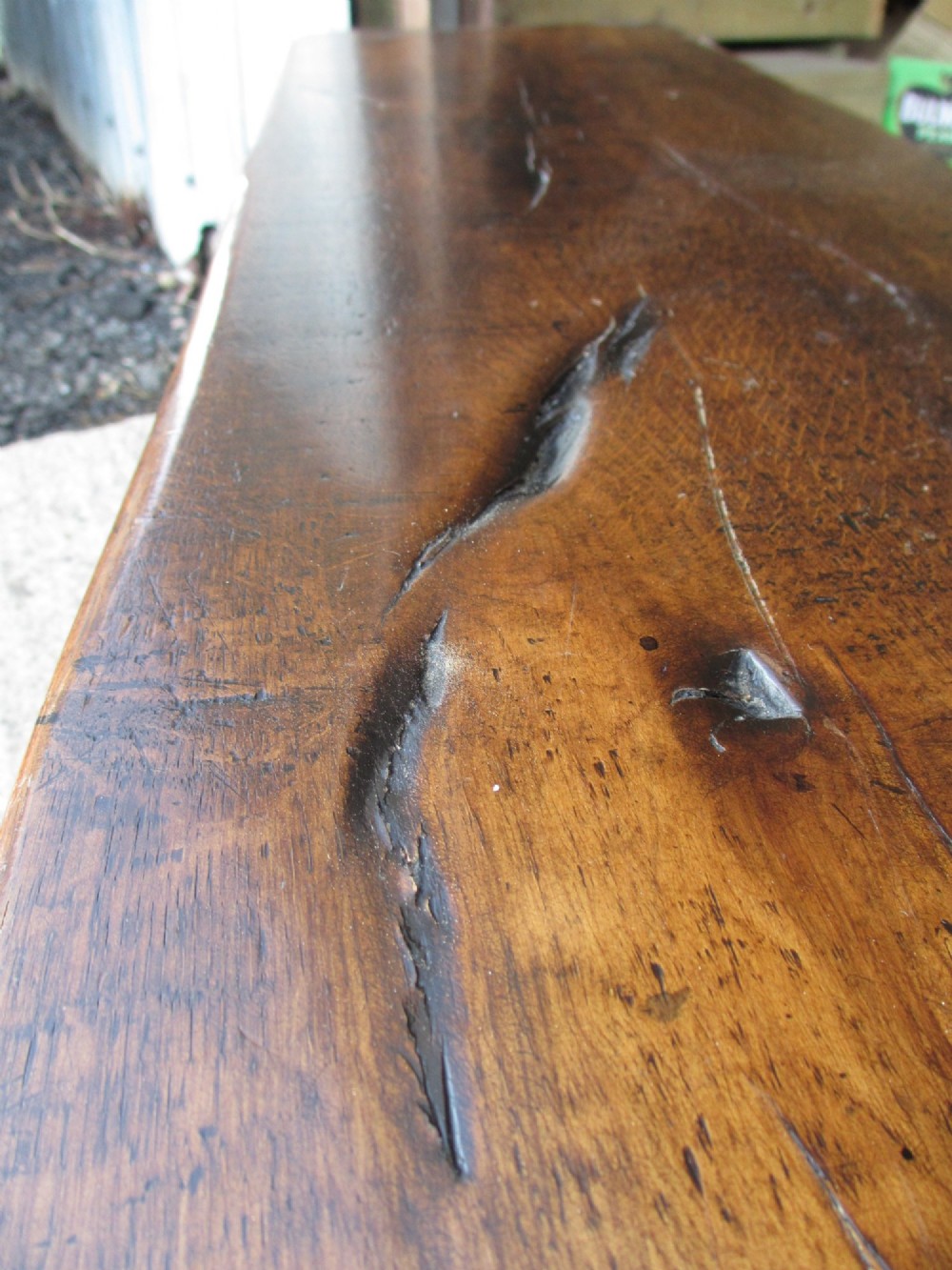 A long Edwardian solid oak bench featuring a rectangular seat and shaped trestle end supports. View X