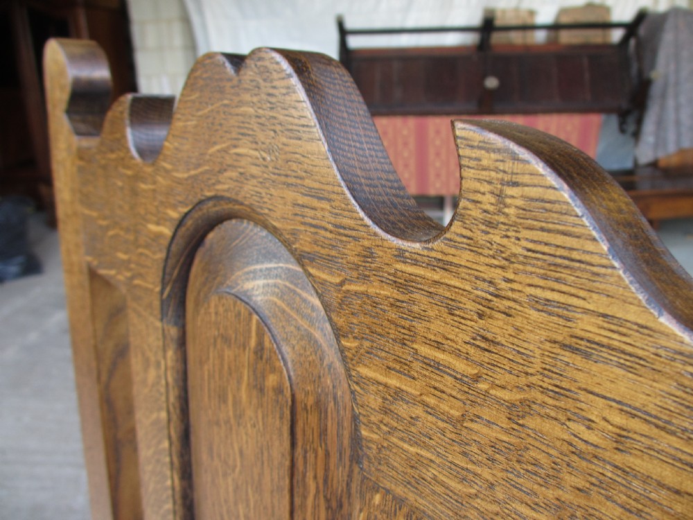 A set of twelve 20th-century oak high-back dining chairs with arched panel backrests and blue upholstered seat pads. View XVI