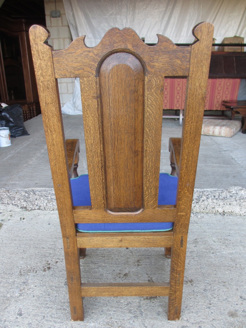 A set of twelve 20th-century oak high-back dining chairs with arched panel backrests and blue upholstered seat pads. View V