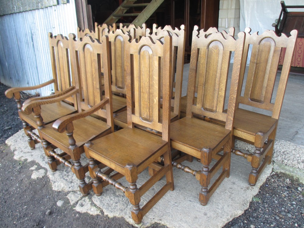 A set of twelve 20th-century oak high-back dining chairs with arched panel backrests and blue upholstered seat pads. View III