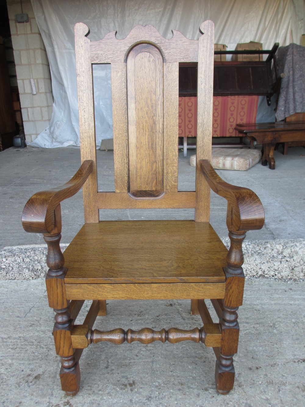 A set of twelve 20th-century oak high-back dining chairs with arched panel backrests and blue upholstered seat pads. View XIII