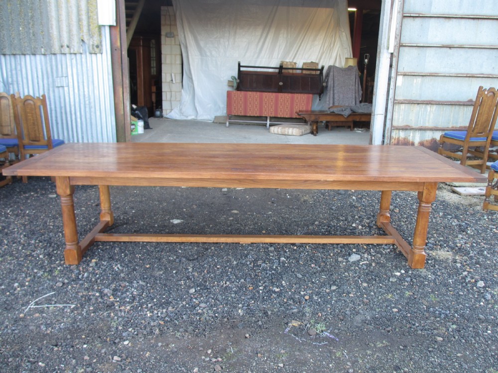 An eleven-foot oak refectory dining table with a planked top, low stretcher base, and heavy turned legs. View III