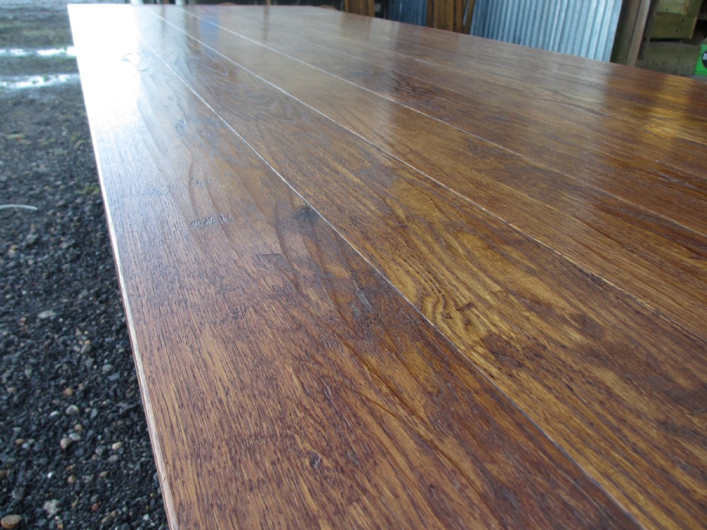 An eleven-foot oak refectory dining table with a planked top, low stretcher base, and heavy turned legs. View V