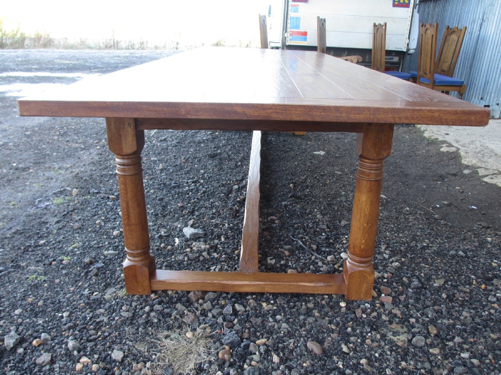 An eleven-foot oak refectory dining table with a planked top, low stretcher base, and heavy turned legs. View VIII
