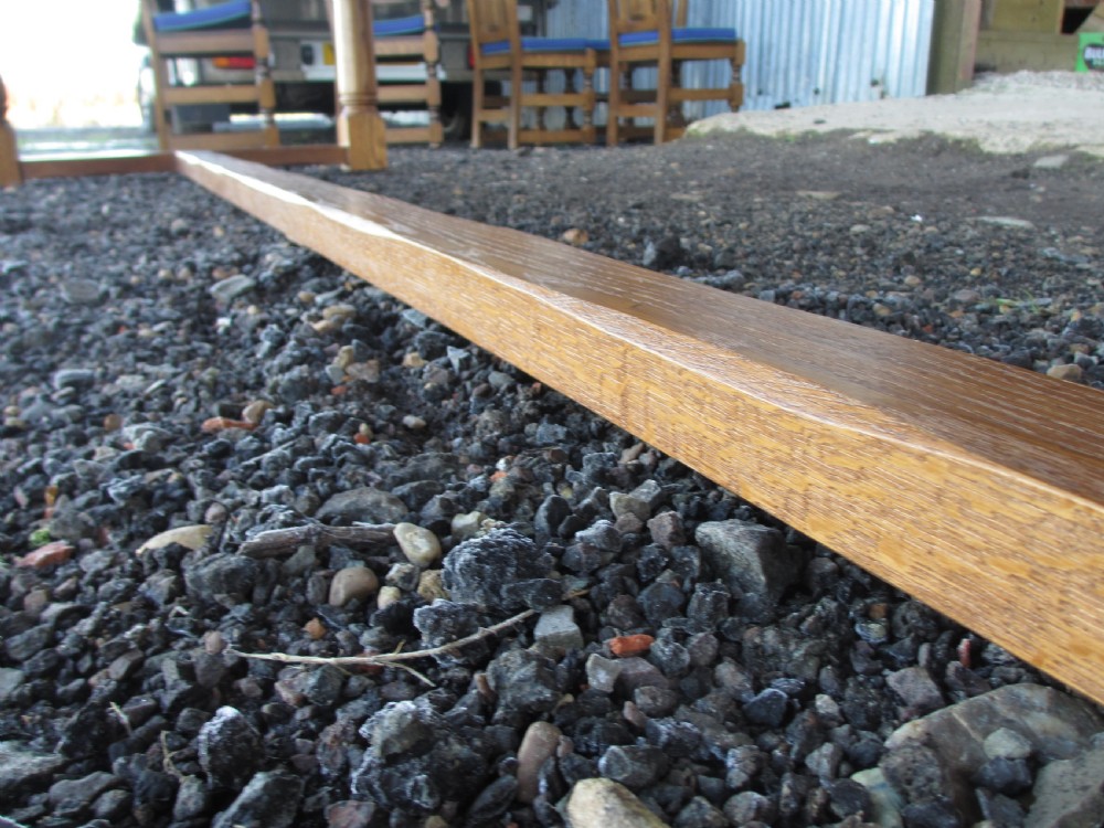 An eleven-foot oak refectory dining table with a planked top, low stretcher base, and heavy turned legs. View XI