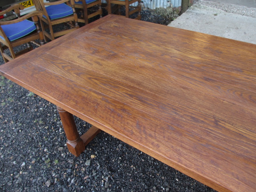 An eleven-foot oak refectory dining table with a planked top, low stretcher base, and heavy turned legs. View XIII