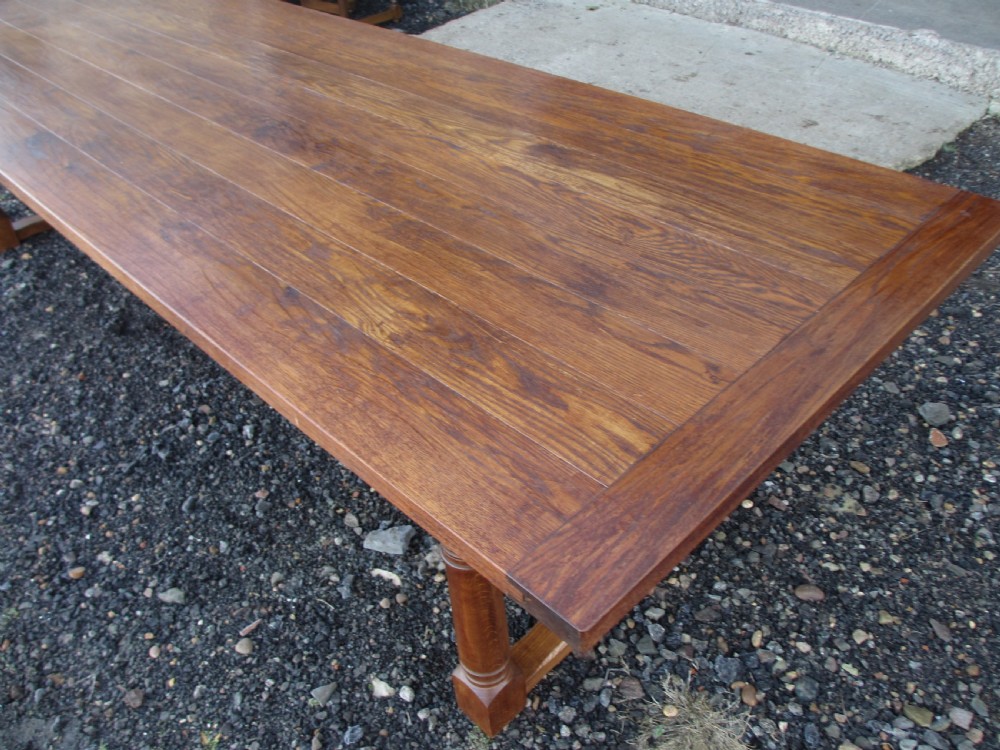 An eleven-foot oak refectory dining table with a planked top, low stretcher base, and heavy turned legs. View XIV