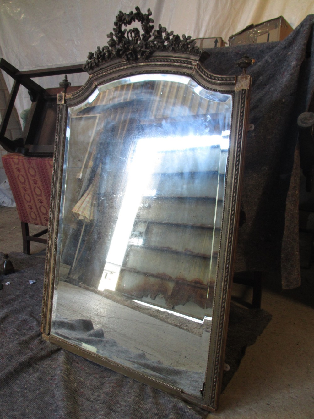 An arched giltwood overmantel mirror with an ornate floral cresting and beaded border details. View III