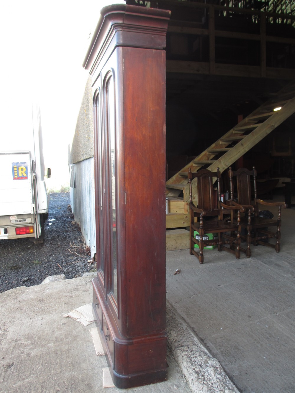 A tall 19th-century mahogany glazed bookcase featuring two long arched glass doors above a base fitted with two drawers. View XII
