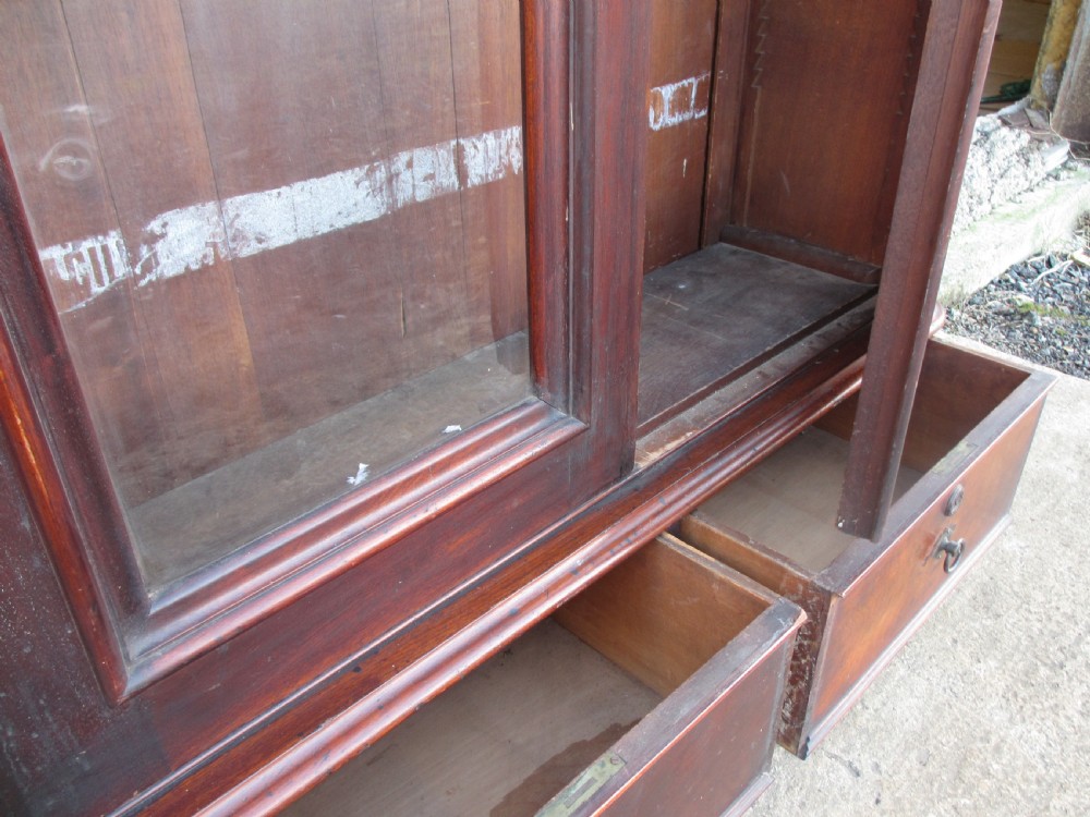 A tall 19th-century mahogany glazed bookcase featuring two long arched glass doors above a base fitted with two drawers. View XVI