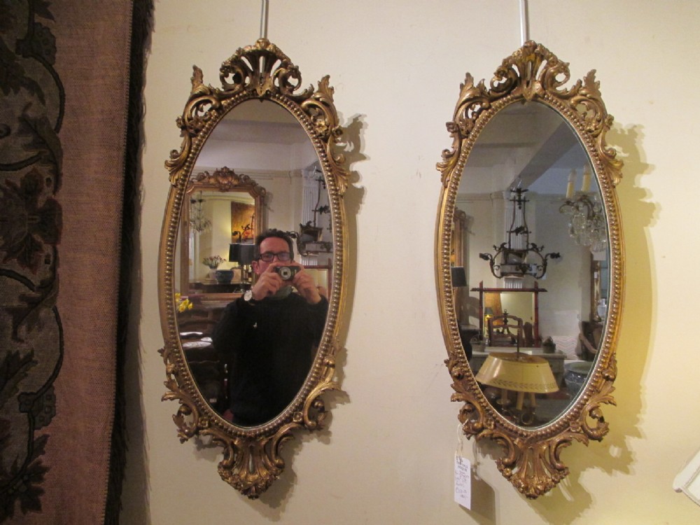 A pair of oval gilt mirrors