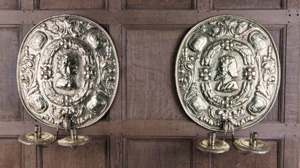 A decorative pair of 19thC repoussé brass wall sconces. 