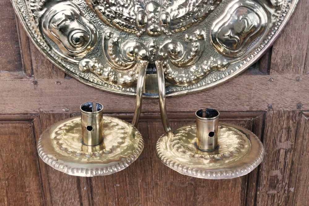 A decorative pair of 19thC repoussé brass wall sconces.  View VII