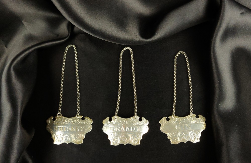 Three Victorian silver decanter labels. 