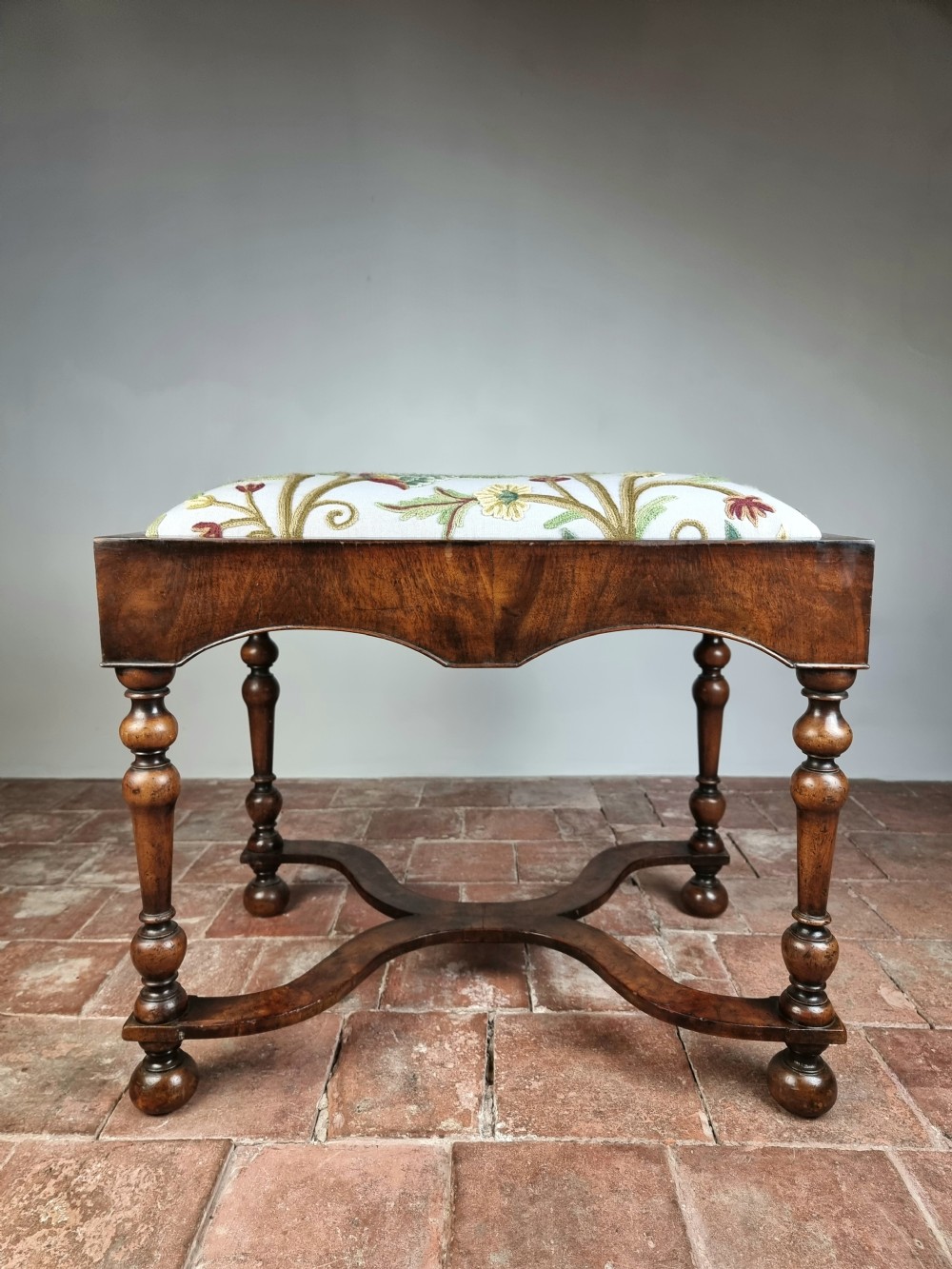 A late 17th century style walnut stool. 